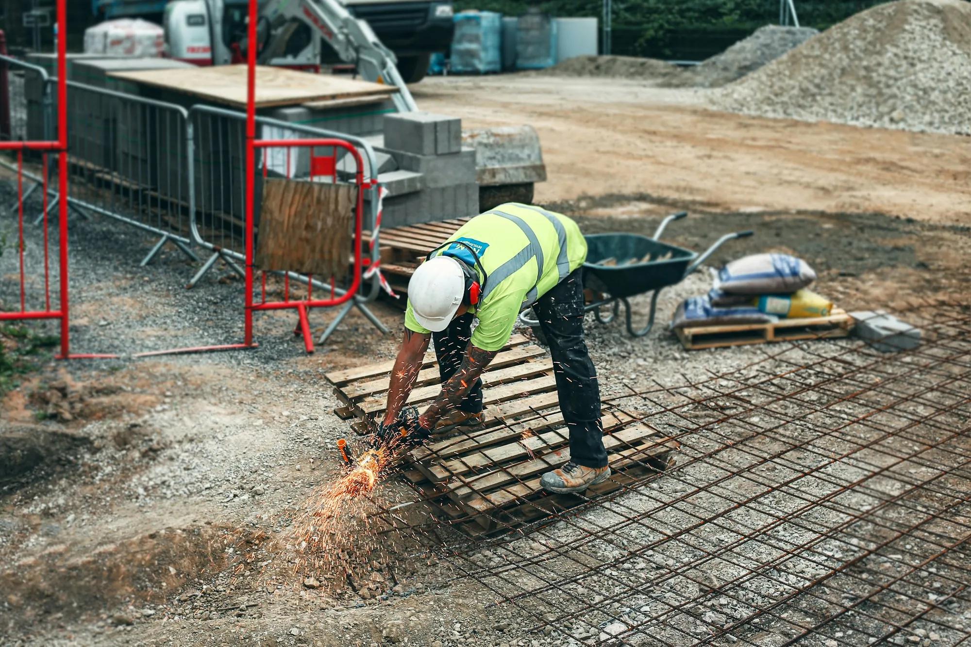 Worker cutting rebar with a grinder on a job site